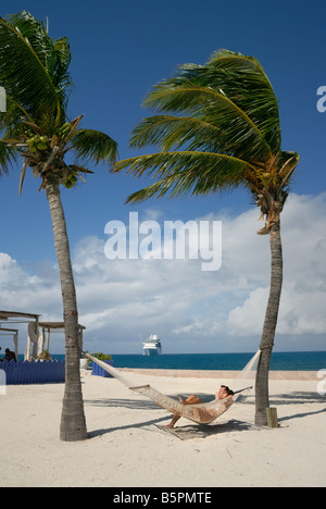 Quelques salons dans un hamac sur la plage de Little Stirrup Cay, Bahamas. Banque D'Images