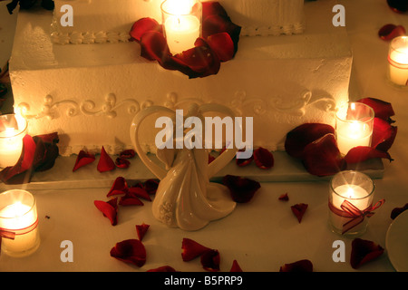 Un gâteau de mariage de fantaisie avec des bougies allumées autour du cake affiché pour une réception de mariage Banque D'Images