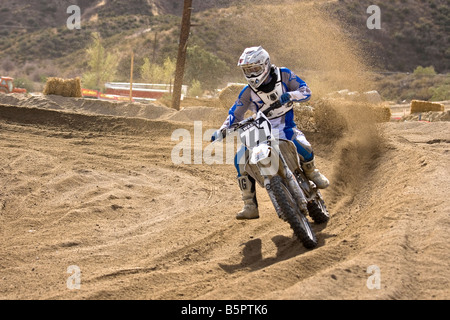 Cross rider déferle sur un coude à Glen Helen Devore circuit en Californie. Banque D'Images