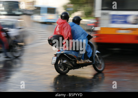 Groupe de jeunes touristes circonscription louer Location scooters cyclomoteurs en pluie dans Rome Italie Banque D'Images