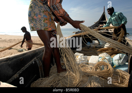 Les pêcheurs du village de Chowara assister à bateaux et filets à Chowara beach nr Kerela Trivandrum Inde du sud de l'état Banque D'Images