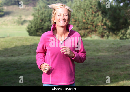 Jeune femme blonde à l'extérieur. Le jogging dans la campagne. Banque D'Images
