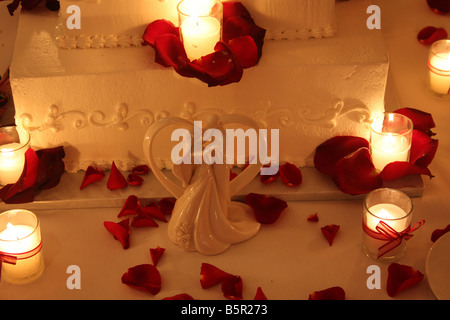 Un gâteau de mariage de fantaisie avec des bougies allumées autour du cake affiché pour une réception de mariage Banque D'Images