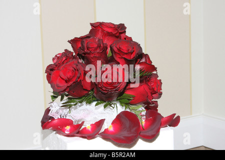 Un beau gâteau de mariage avec des roses rouges en haut affiche pour une réception de mariage Banque D'Images