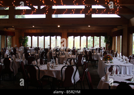 Une salle de réception de mariage mis en place pour un dîner plus tard l'arrivée des invités pour célébrer une cérémonie de mariage Banque D'Images