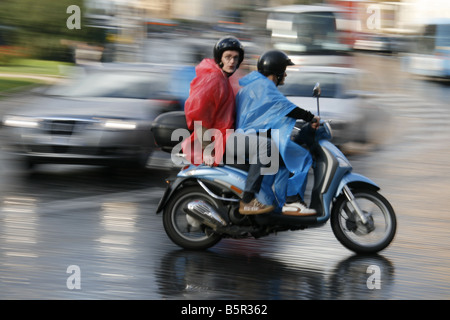Groupe de jeunes touristes circonscription louer Location scooters cyclomoteurs en pluie dans Rome Italie Banque D'Images