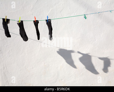 Un lave-ligne et des pinces à linge avec chaussettes laissées pour compte et les ombres au soleil à Fethiye, Turquie Banque D'Images