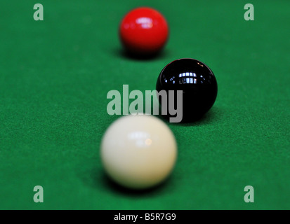 Billard pool balls alignés, la bille blanche coincés derrière la boule noire, le feutre vert comme un tapis d'herbe. Banque D'Images