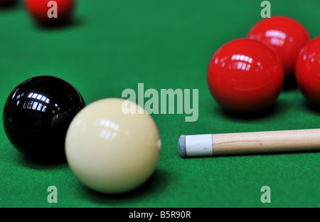 Billard pool balls alignés, la bille blanche coincés derrière la boule noire, le feutre vert comme un tapis d'herbe. Banque D'Images