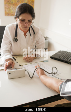 Le médecin vérifie la pression artérielle du patient Banque D'Images