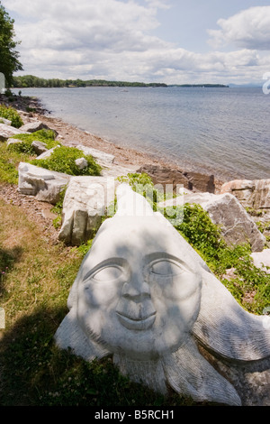 Visage sculpté dans une roche sur le bord d'un grand lac Banque D'Images