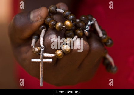 Détail des mains et chapelet pendant la représentation de l'Afrique du Chemin de Croix se souvenait à Pâques à Lomé, Togo. Banque D'Images