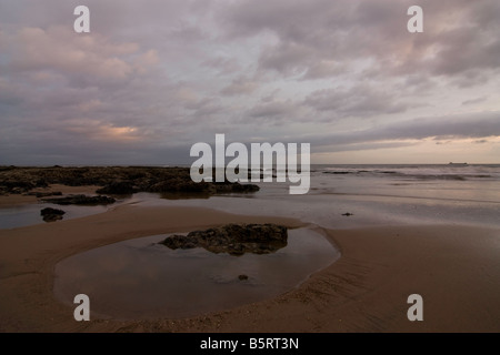 Lever du soleil à Seaham plage avec vue sur la mer du Nord avec bateau sur l'horizon Banque D'Images