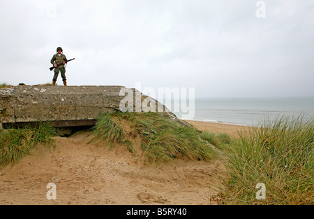 Acteur habillé en D-Day American soldier debout sur un bunker allemand à Utah Beach en Normandie, France Banque D'Images