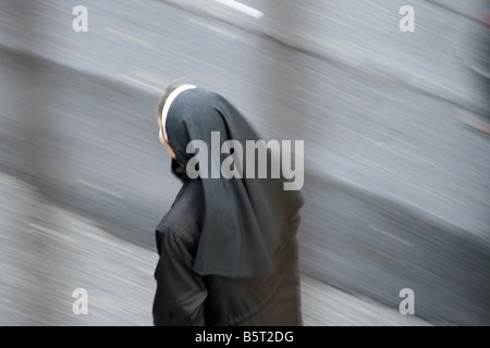 Une moniale walking in street dans la pluie à Rome Italie Banque D'Images