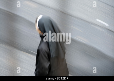 Une moniale walking in street dans la pluie à Rome Italie Banque D'Images