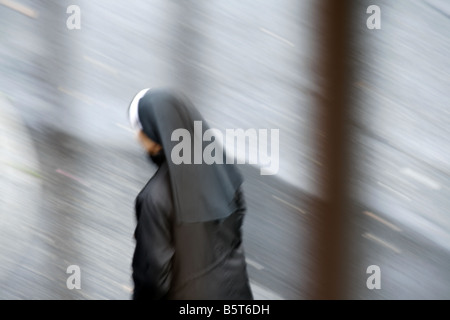 Une moniale walking in street dans la pluie à Rome Italie Banque D'Images