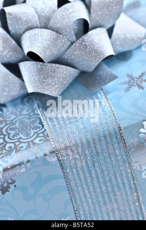 Boîte cadeau de Noël enveloppé dans du papier bleu avec ruban d'argent close up Banque D'Images