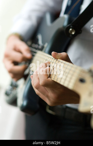 Close shot of teenage boy's hands playing et guitare électrique à selective focus Banque D'Images