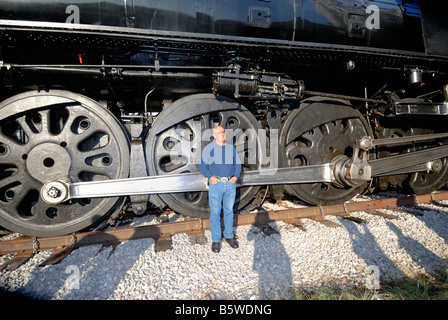Un homme se distingue par les roues d'une Union Pacific 1944 machine à vapeur. New York, USA Banque D'Images