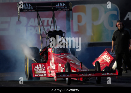 Doug Kalitta's 'Mac' outils NHRA Top Fuel dragster - burning out à la ligne de départ. Banque D'Images