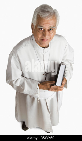 Portrait d'un prêtre tenant la Bible et smiling Banque D'Images