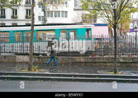 Metropolitan à Paris avec un homme qui marche et la lecture d'un document d'informations français sur la rue Banque D'Images