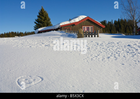 Chalet de vacances de neige et un smiley en forme de coeur dessiné dans la neige Norvège Valdres Banque D'Images