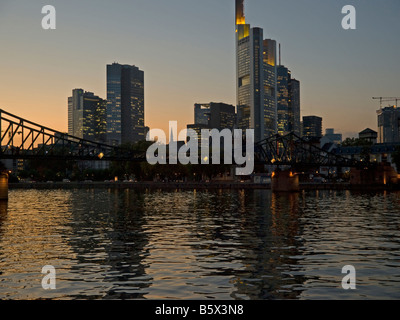 Rivière Main dans la lumière du soir avec le pont Eisener Steg avec skyline allégé avec tours de bureaux de la banque dans l'arrière-plan Frankf Banque D'Images