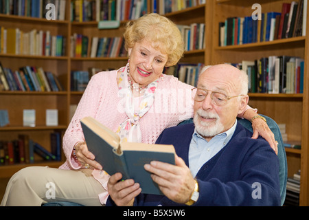 Senior couple bénéficiant d'un bon livre dans la bibliothèque Banque D'Images