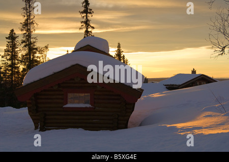 Maison de vacances chalets dans paysage de neige au coucher du soleil la Norvège Valdres Banque D'Images