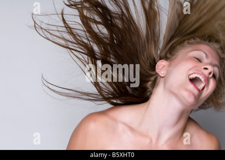 Happy blonde woman projetant des cheveux. Banque D'Images