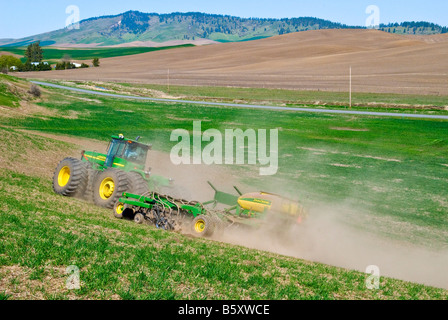 Un tracteur tire un semoir pneumatique à replanter le blé d'hiver endommagé par la neige au printemps dans la région de Washington Palouse Banque D'Images