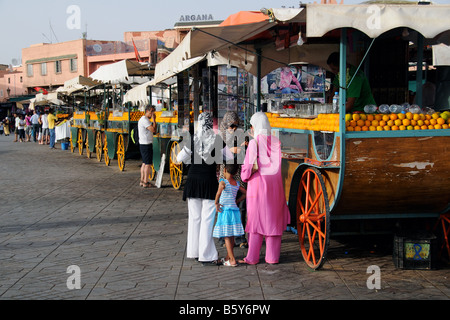 Les femmes à un décrochage de jus d'Orange dans la place Jemaa el Fna Maroc Marrakeck Banque D'Images