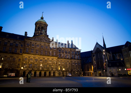 La nuit tombe à Amsterdam sur la Place Dam, bordée par le Palais Royal et Nieuwe Kerk Banque D'Images