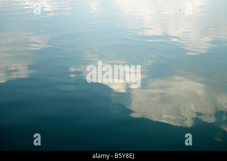 Les nuages blancs et ciel bleu reflété dans un lac ou une rivière avec des ondulations sur l'eau Banque D'Images