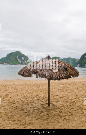 Parapluie de plage sur une île dans la baie d'Halong, Vietnam Banque D'Images