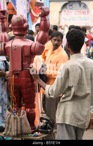 Un homme exploite un robot à Bangalore, Inde. Le Robot raconte l'avenir de ceux qui mettent les écouteurs et écouter. Banque D'Images