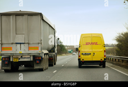 Un DHL van dépasse un poids lourd sur l'A14, Suffolk, UK Banque D'Images