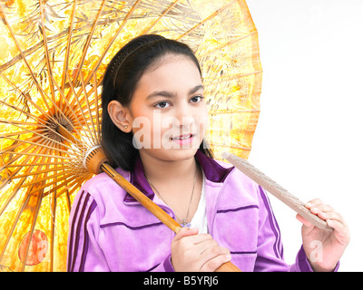 Une jolie fille asiatique souriant et tenant un parapluie de l'est traditionnel Banque D'Images