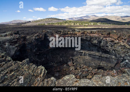 Un trou béant dans le sol, l'entrée de l'Indien géant de lave Tunnel de cratères de la Lune National Monument, New York. Banque D'Images