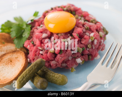 Steak tartare avec Cornichons, croûtons et un jaune d'Oeuf Banque D'Images