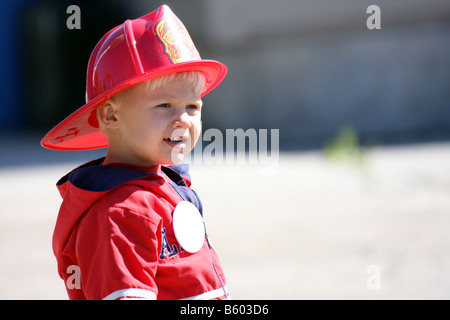 Un petit garçon portant un chapeau ou casque pompiers junior à un salon de la sécurité incendie Banque D'Images