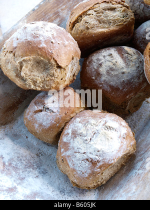 Loafs de pain fraîchement cuit au four dans un plateau en bois avec de la farine Banque D'Images