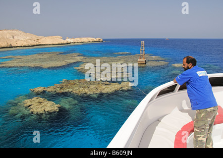 L'homme sur le bateau à regarder les récifs coralliens Banque D'Images