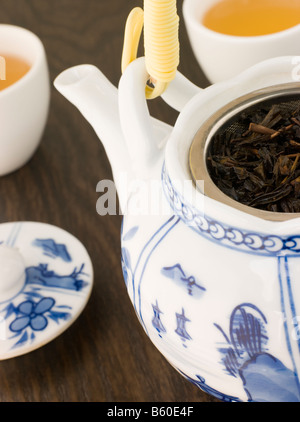 Feuilles de thé vert dans une théière avec tasse Banque D'Images