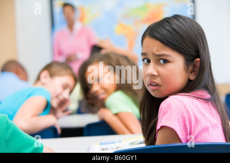 Dans la classe l'élève victime d'intimidation par les étudiants en arrière-plan (selective focus) Banque D'Images