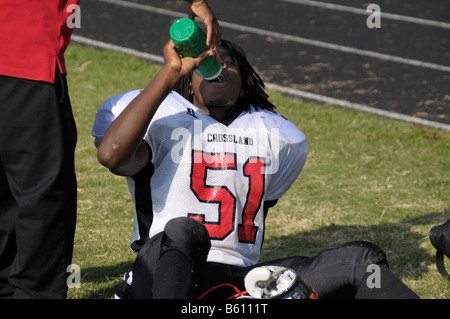 High school football player prend une pause et obtient un verre d'eau au cours d'un match à Oxon Hill, Maryland Banque D'Images