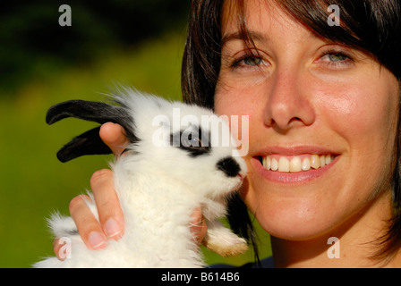 Jeune femme de caresser un lapin nain (Brachylagus idahoensis) Banque D'Images