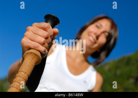 Jeune femme en randonnée dans les montagnes boisées tenant un pôle trekking, vallée du Stubaital, Tyrol, Autriche, Europe Banque D'Images